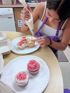 student decorating a cupcake