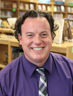 Man in purple shirt in the library